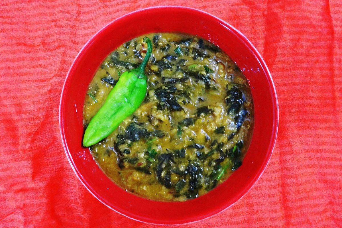 Red lentil dal with spinach in a red bowl