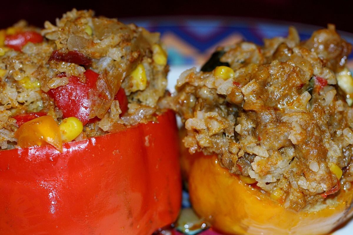 Red and yellow bell peppers stuffed with rice, beans, and corn