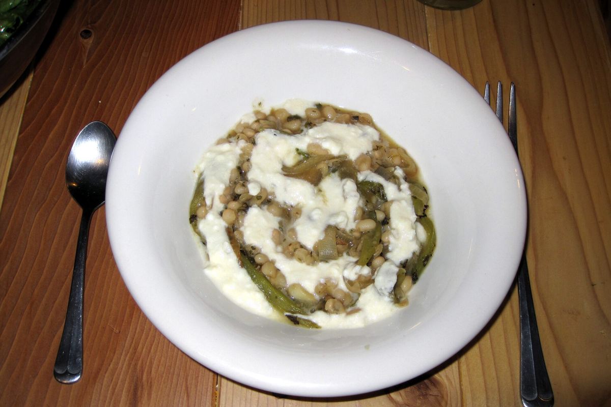 Bowl of creamy white bean chili with a swirl of sour cream